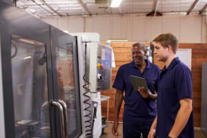 Engineer Training Male Apprentice On CNC Machine